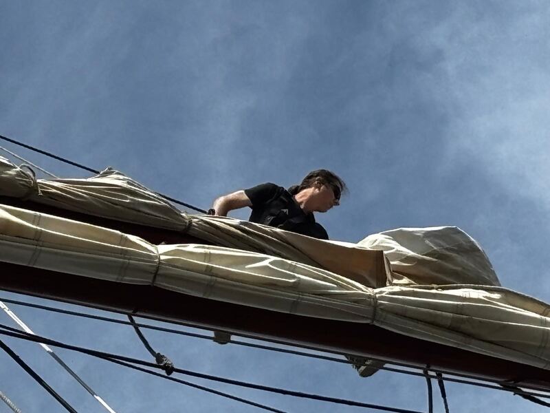 On the boom, stowing sail