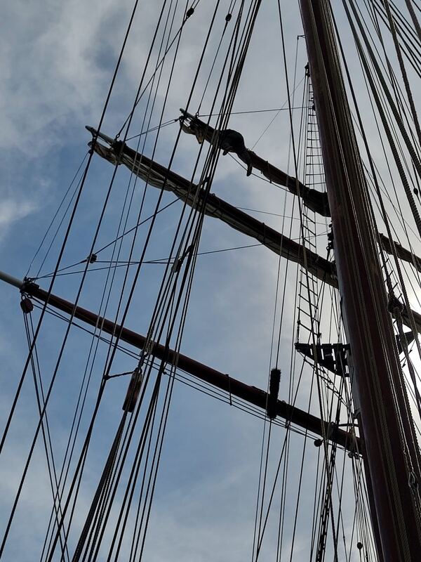 Up the foremast, a crew member out on the yard